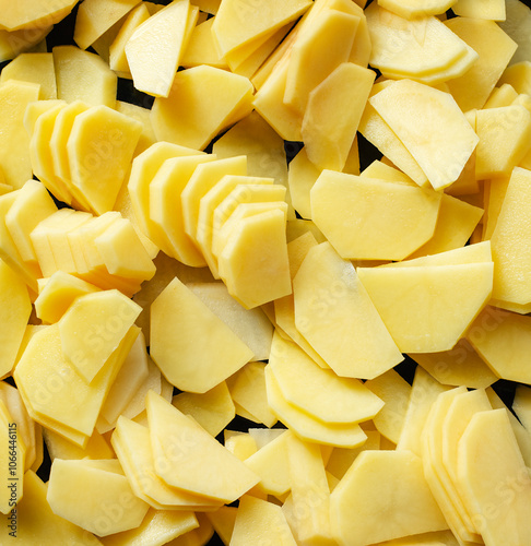 Slices of raw potatoes. Peeled potatoes cut into slices on a baking sheet.