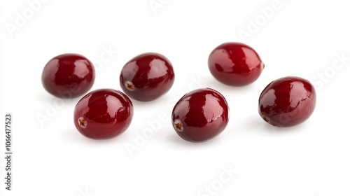 A bunch of red cranberries are spread out on a white background