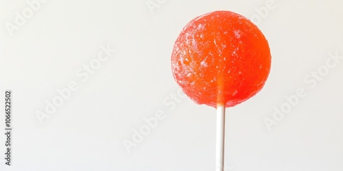 A bright red fruity lollipop rests on a tropical orange cacao pop against a white backdrop. This summer delight offers a gourmet sorbet bar experience with a crunchy mint frozen treat on a stick.