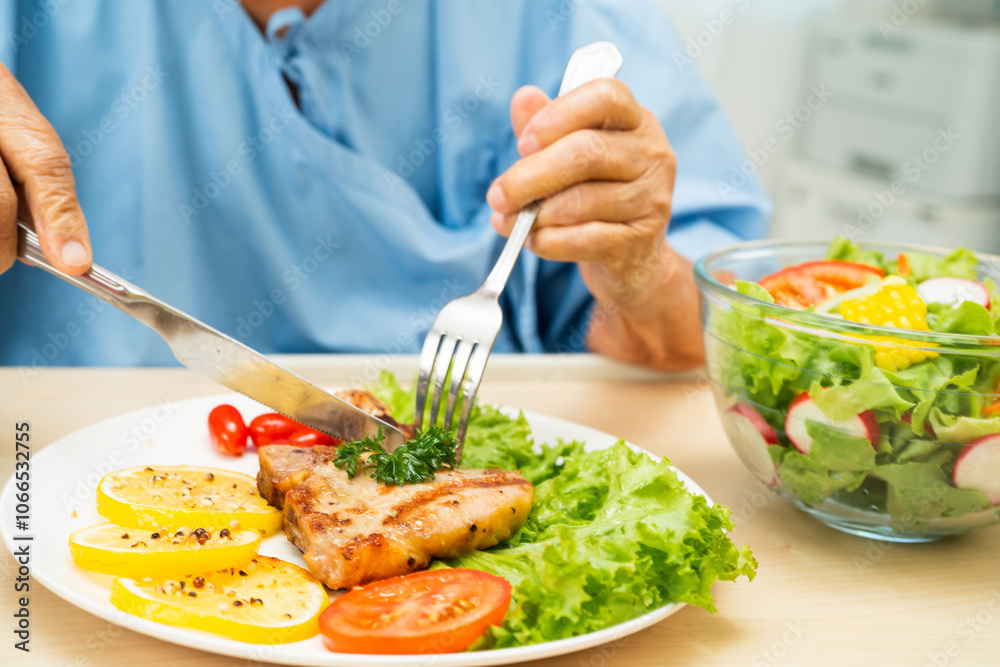 custom made wallpaper toronto digitalAsian senior woman patient eating pork chop stake and vegetable salad for healthy food in hospital.