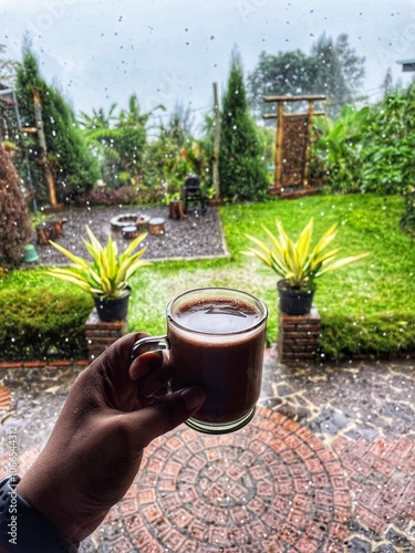 Pasuruan, Indonesia - November 12, 2024: Sipping a hot palm sugar latte on a rainy day photo