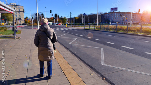 Tram stop where elderly old woman are seen waiting. The concept of a senior on the street.