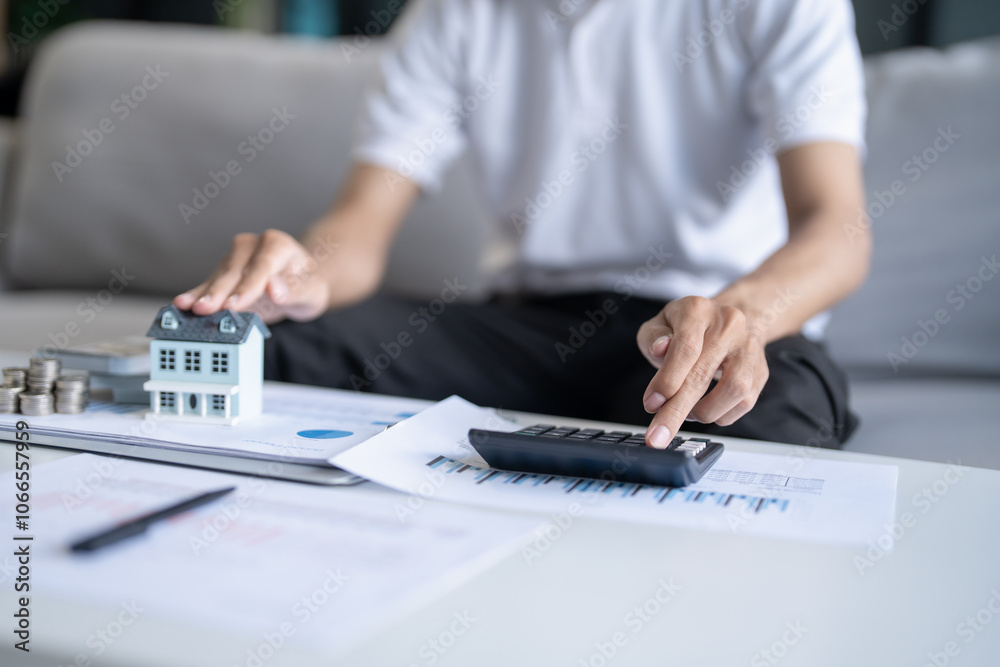 Saving money. Man calculate finances home pay bills taxes savings economy financial at home and saving money stacking coins with calculator Saving money. Man calculate finances home pay bills taxes savings economy financial at home and saving money stacking coins with calculator
