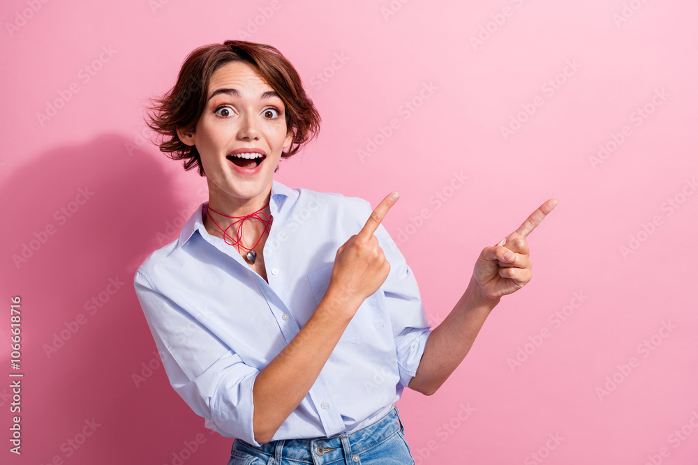 Photo of astonished woman with accessories dressed blue shirt indicating at impressive sale empty space isolated on pink color background Photo of astonished woman with accessories dressed blue shirt indicating at impressive sale empty space isolated on pink color background