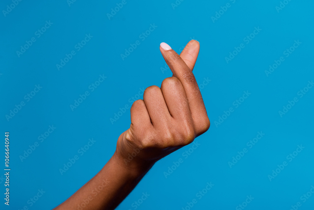 Cropped close up photo of lady hand fingers make korean love heart gesture isolated on blue color background Cropped close up photo of lady hand fingers make korean love heart gesture isolated on blue color background