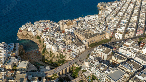 Aerial view at sunset of the historic center of Polignano a Mare, in the province of Bari, Puglia, Italy. On the left is Lama Monachile beach, the most important and famous beach in town. photo