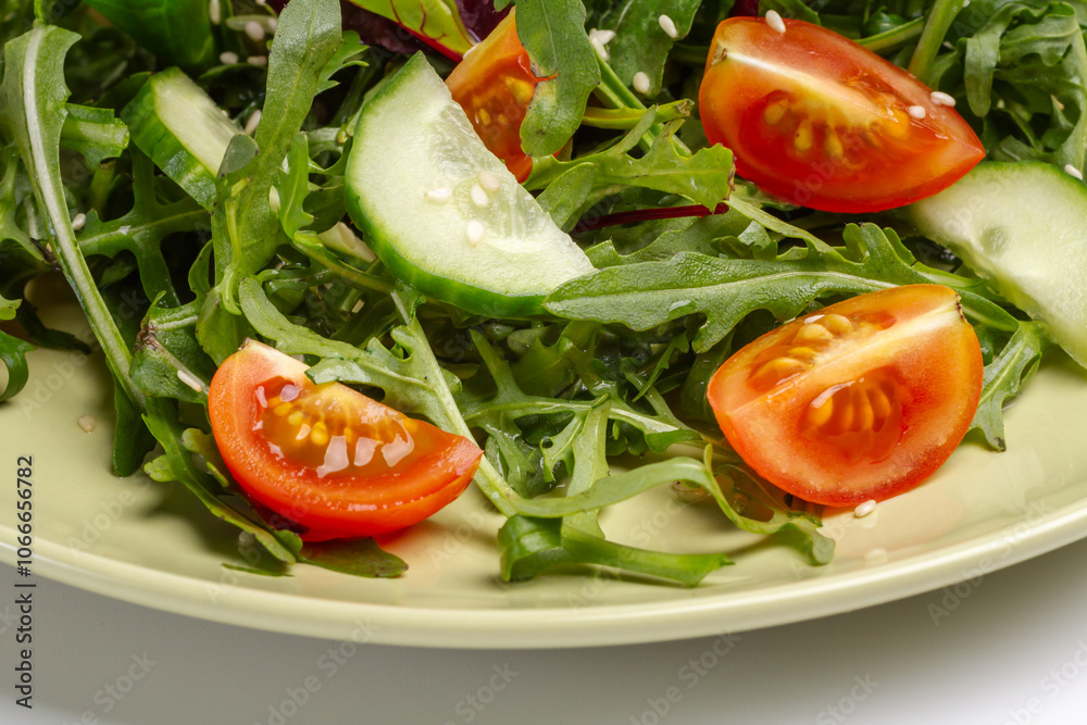 Vegetable salad of tomato, cucumber, greens with sesame on the plate. Vegetable salad of tomato, cucumber, greens with sesame on the plate.