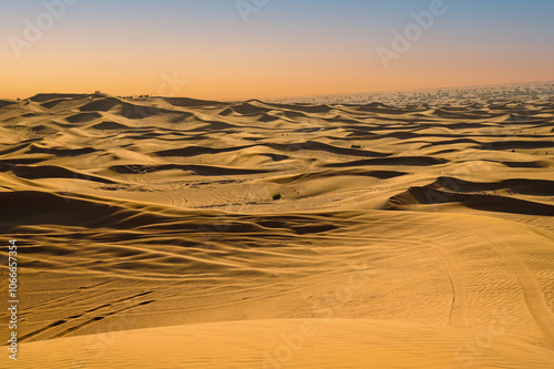 A sweeping desert horizon blanketed with golden dunes, stretching endlessly beneath the open sky