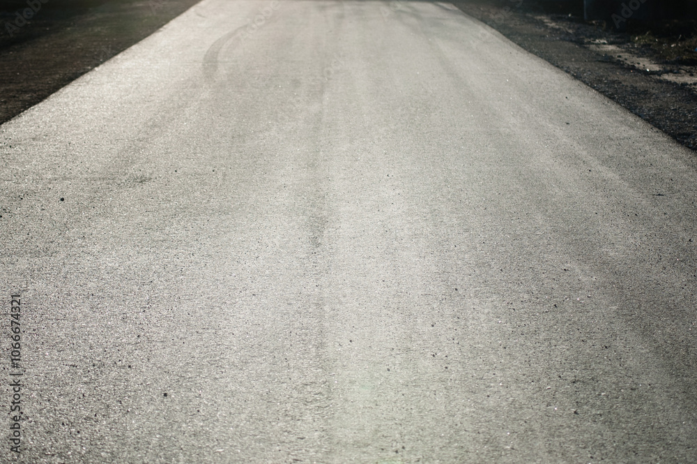 Naklejka premium The photo shows a close-up of grey asphalt road