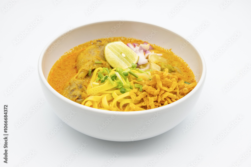 KhaoSoi, Thai Northern Curry Noddle Soup with chicken, Thai traditional food, Northern style on the wooden table KhaoSoi, Thai Northern Curry Noddle Soup with chicken, Thai traditional food, Northern style on the wooden table
