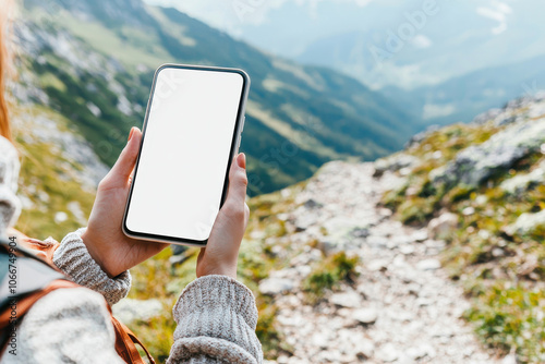 A person holding a smartphone in a scenic mountain landscape, perfect for showcasing technology in nature. photo