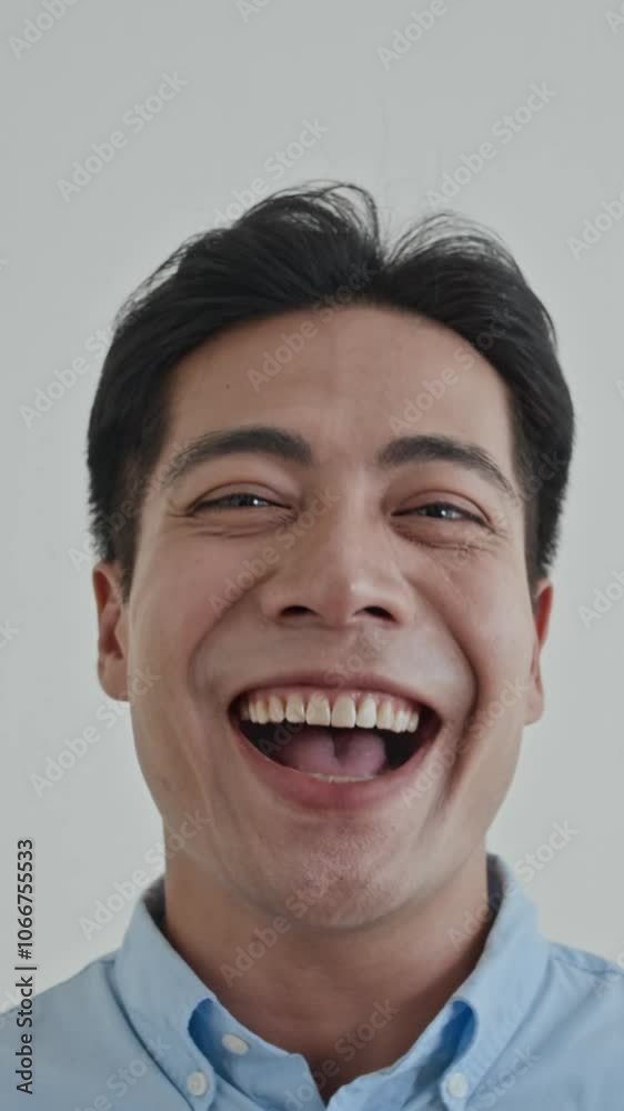 Vertical portrait of Asian male millennial laughing at camera on white background Vertical portrait of Asian male millennial laughing at camera on white background