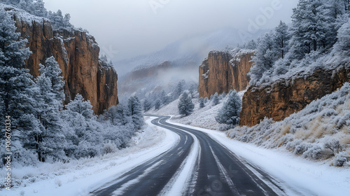A dramatic photography of a narrow mountain pass, with the Rocky Mountains towering on either side, their jagged cliffs coated in frost and snow falling gently from a gray, overcast sky.