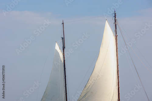 Ocean liner or Sea sailing ship concept, Selective focus of white boat canvas with rops on spar, Sailcloth of sailboat with mainmast and boat hoist rope to spread the sails with blue sky as background