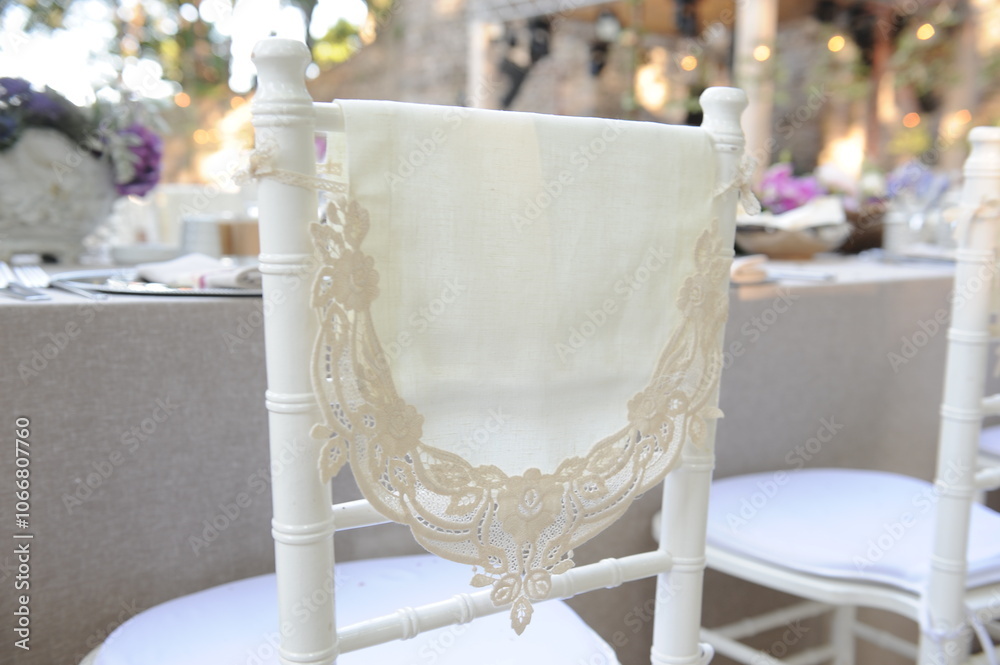 Outdoor Wedding: A White Chiavari Chair with a Lace Overlay and a Simple Satin Sash Set Against a Lush Garden.