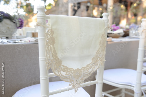 Obraz na płótnie Outdoor Wedding: A White Chiavari Chair with a Lace Overlay and a Simple Satin Sash Set Against a Lush Garden. w salonie