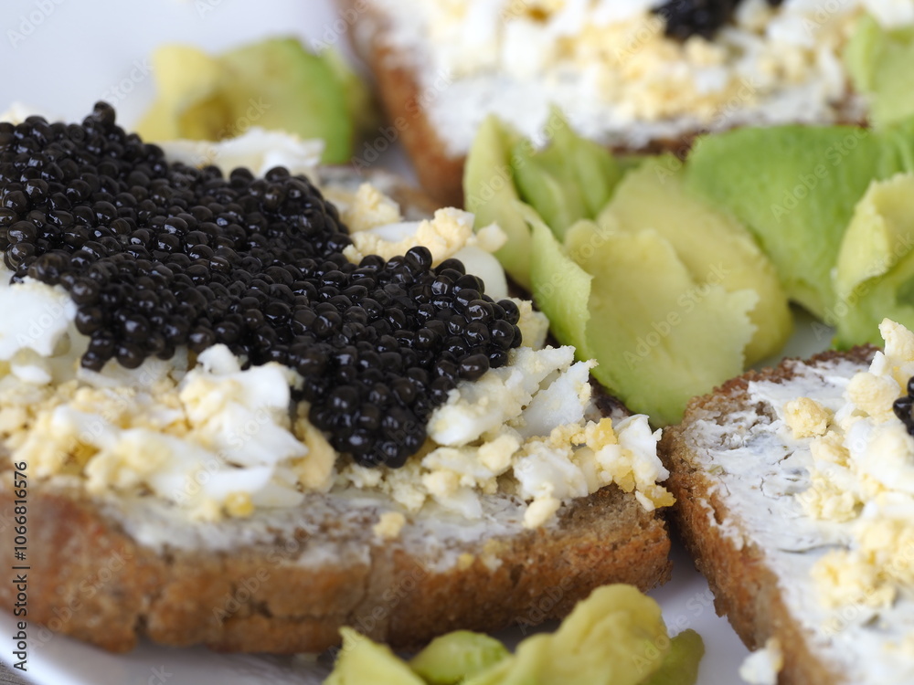 Gourmet Appetizer with Black Caviar on Bread with Avocado and Egg Gourmet Appetizer with Black Caviar on Bread with Avocado and Egg
