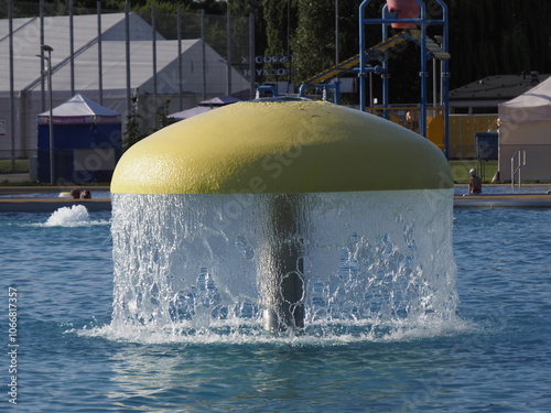 Yellow Dome Fountain in Park with Waterfall and Trees in Background photo