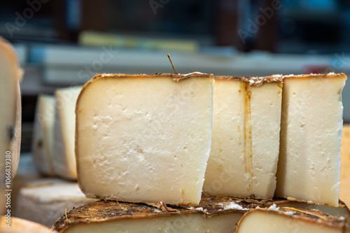 Piece of tasty Basque Brebis Fume smoked sheep cheese produced in south-western France, Northern Basque Country on local farmers market photo