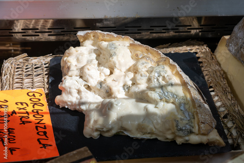 Italian food, buttery or runny blue cheese extra made from cow milk in Gorgonzola, Milan, Italy in large box on Italian farmers market