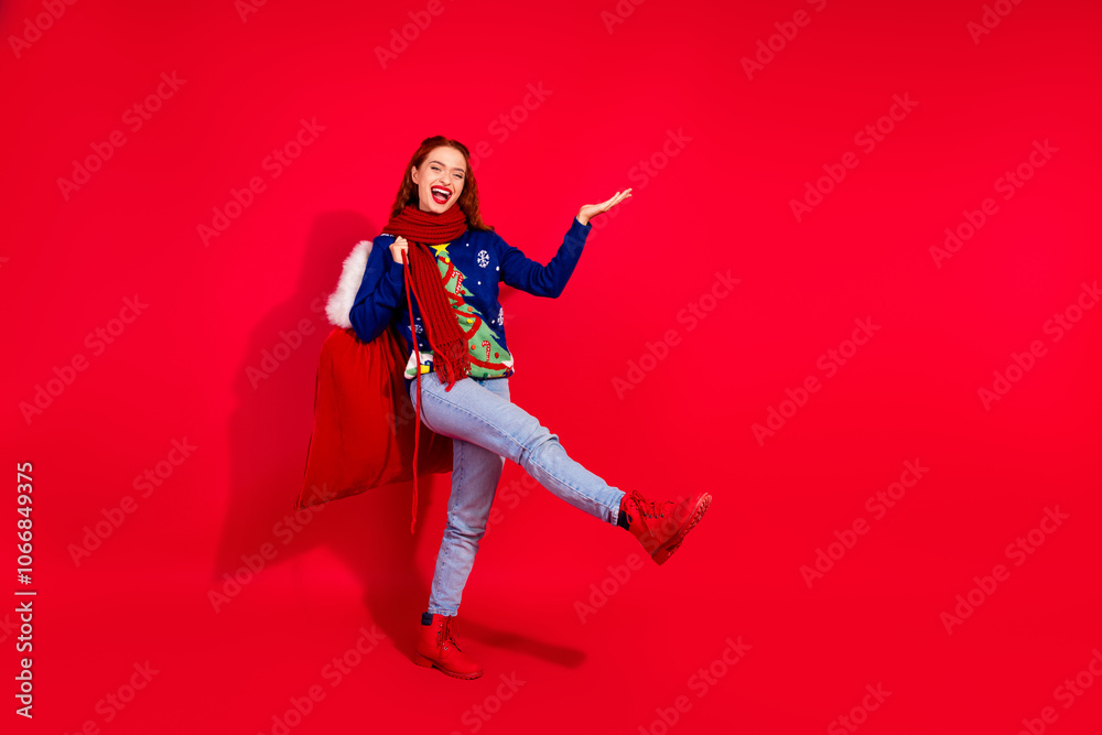 Full size photo of young girl hold empty space gift sack dance wear trendy blue christmas outfit masquerade theme party on red background Full size photo of young girl hold empty space gift sack dance wear trendy blue christmas outfit masquerade theme party on red background