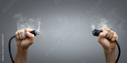 Hands Holding a Smoking Power Cord