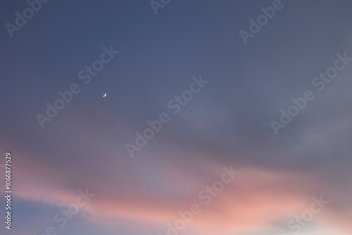 half moon on twilight blue and orange sky in evening