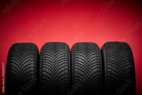 Car tires, winter wheels isolated on red background