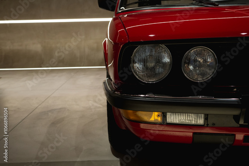 Close-up of the front of the car against the background of a wall and lights