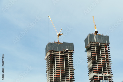 Obraz na płótnie The construction of modern skyscrapers involves the use of cranes and various advanced technologies w salonie