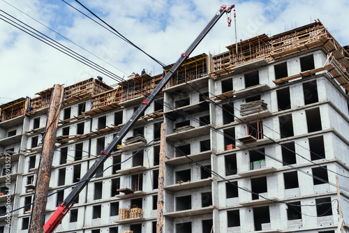 Obraz na płótnie The ongoing construction of a multistory building features cranes and scaffolding raised overhead w salonie