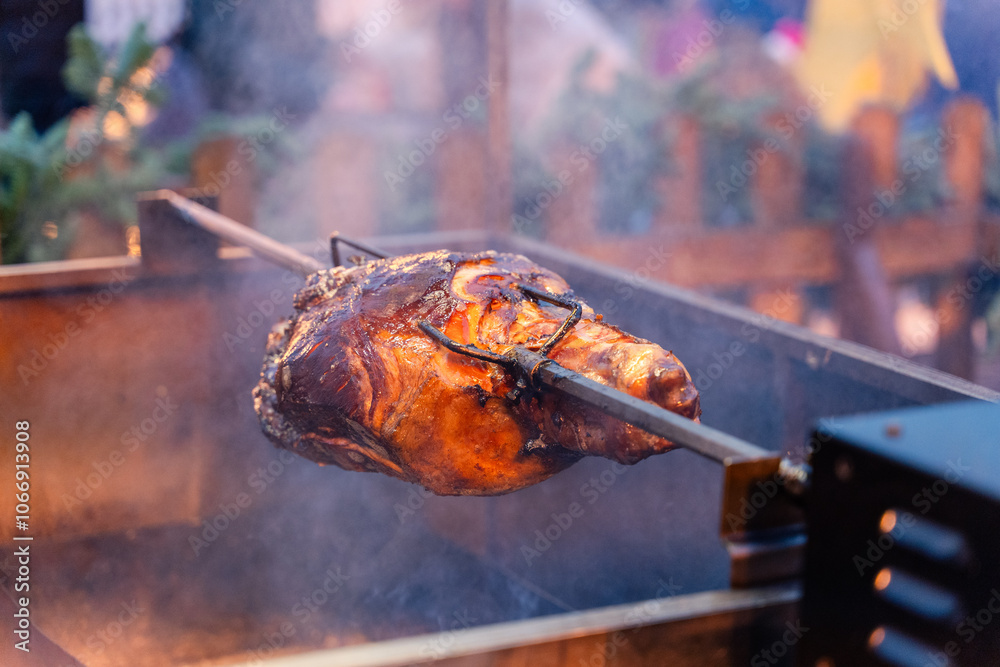The artful and delicious slow roasting of various meats on a spit during an outdoor feast event