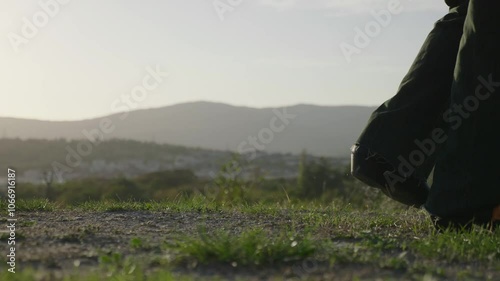 The legs of a cowboy in Cossacks walk on the grass