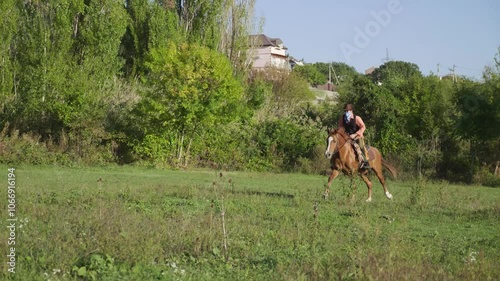 A rider on a horse in a field is engaged in riding