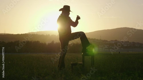 A cowboy lights a cigar at sunset