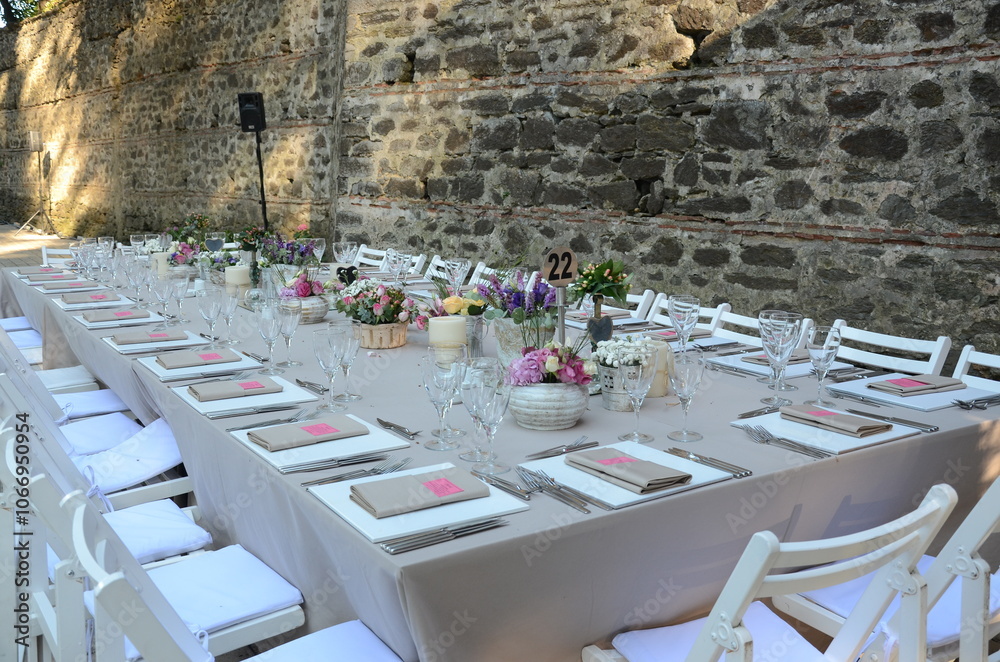 Beautiful Wedding Decor: Tables with Lush Floral Arrangements and Candles Outdoors at Evening