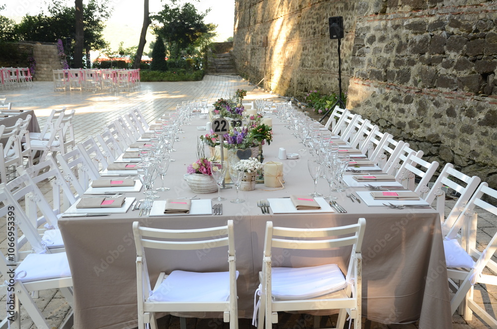 Beautiful Wedding Decor: Tables with Lush Floral Arrangements and Candles Outdoors at Evening