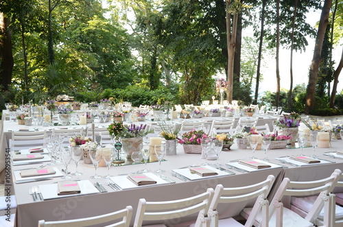 Obraz na płótnie Beautiful Wedding Decor: Tables with Lush Floral Arrangements and Candles Outdoors at Evening w salonie