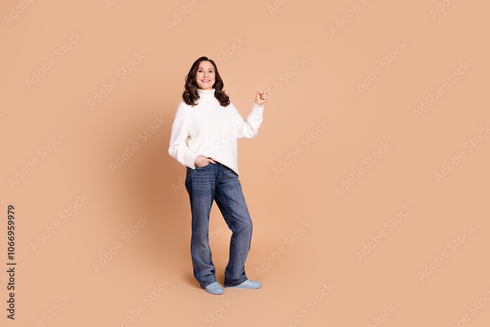 Photo of lovely cheerful senior woman wear stylish clothes recommend empty space isolated on beige color background Photo of lovely cheerful senior woman wear stylish clothes recommend empty space isolated on beige color background