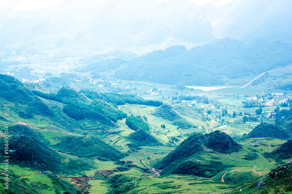 Fototapeta premium a green valley with a road in the background