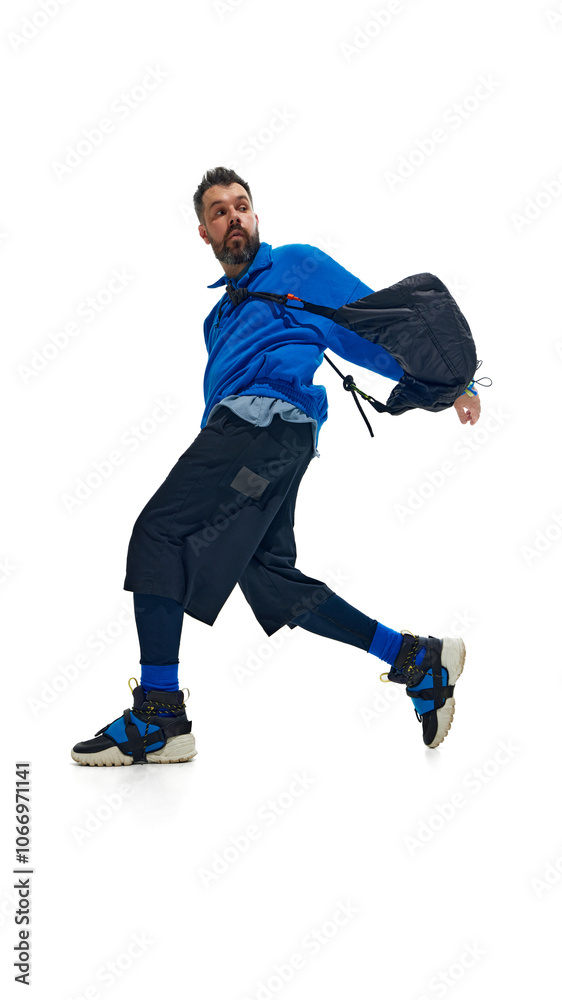 Fashion-forward man in vibrant blue outfit, captured mid-movement with dynamic twist. against white studio background. Concept of fashion and style, beauty, trendy, sport and casual. Ad Fashion-forward man in vibrant blue outfit, captured mid-movement with dynamic twist. against white studio background. Concept of fashion and style, beauty, trendy, sport and casual. Ad
