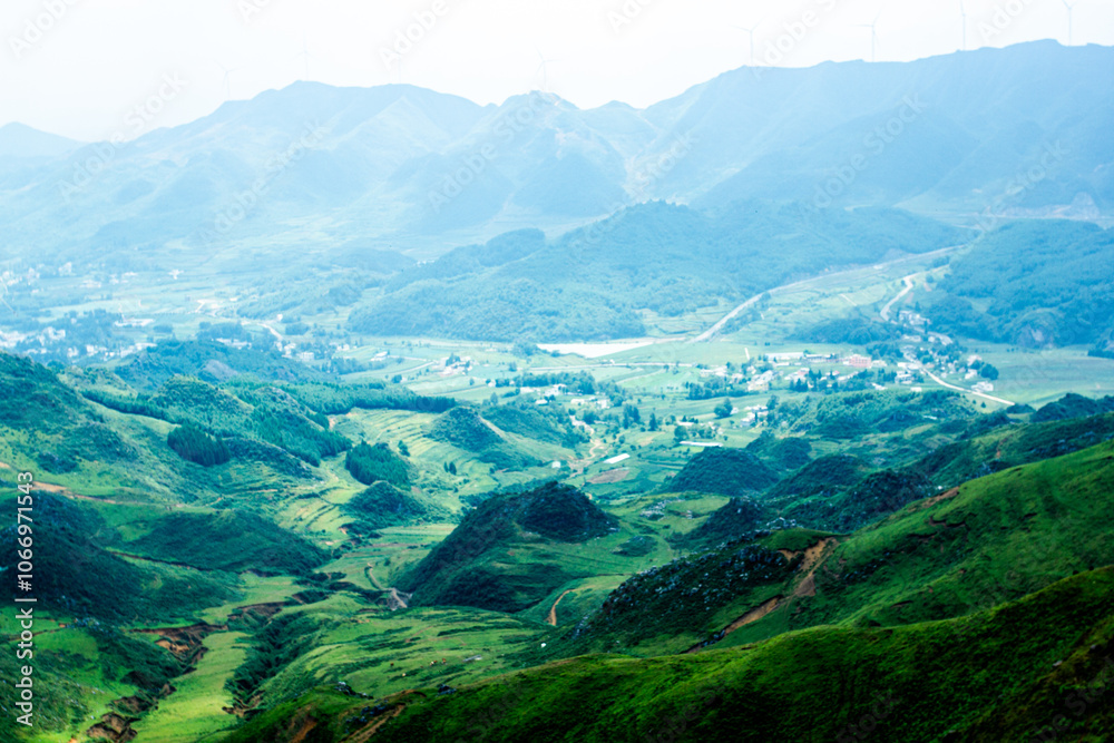 Fototapeta premium a green valley with a road in the background