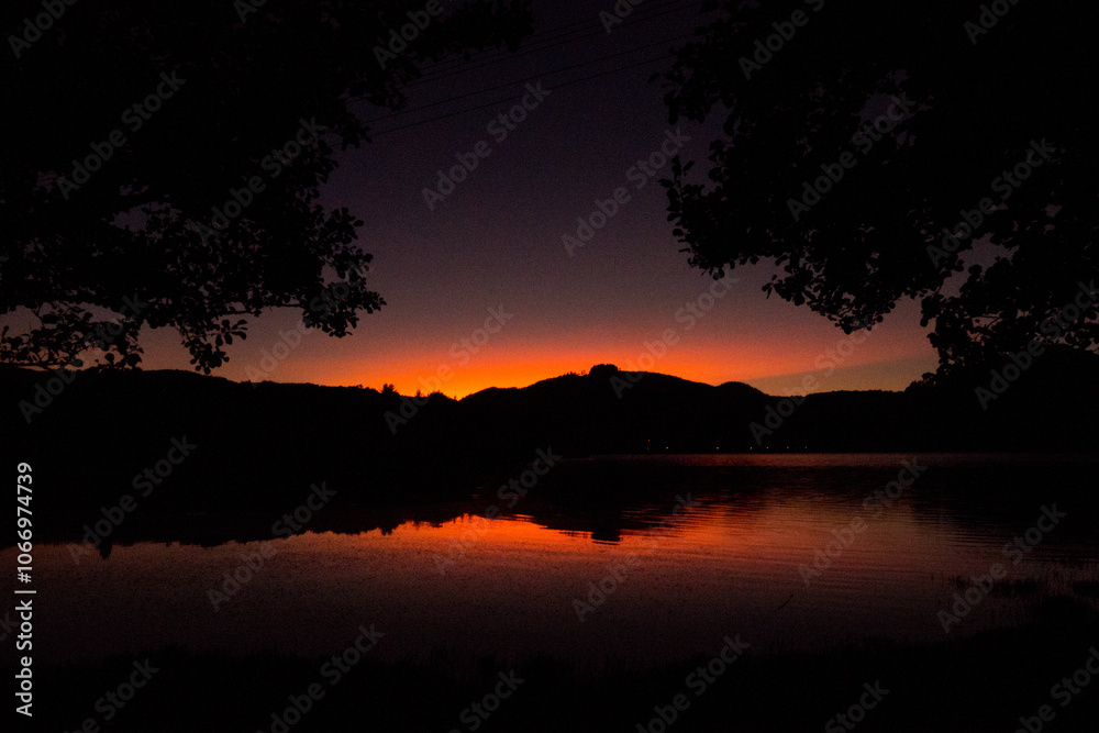 Obraz premium Sunset reflecting with red/orange hue in Sete Cidades volcanic lake in San Miguel island in Azores