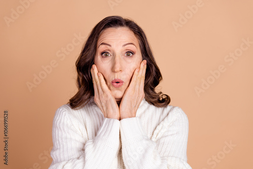 Photo of anxious embarrassed senior woman wear white stylish clothes isolated on beige color background