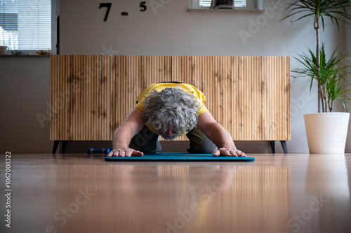 Senior practicing child’s pose in home yoga routine