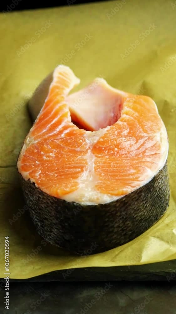 Raw salmon steak. Hands put fresh salmon steaks on parchment paper, close up. Fresh fish, ready to cook. Omega 3 and protein food Raw salmon steak. Hands put fresh salmon steaks on parchment paper, close up. Fresh fish, ready to cook. Omega 3 and protein food