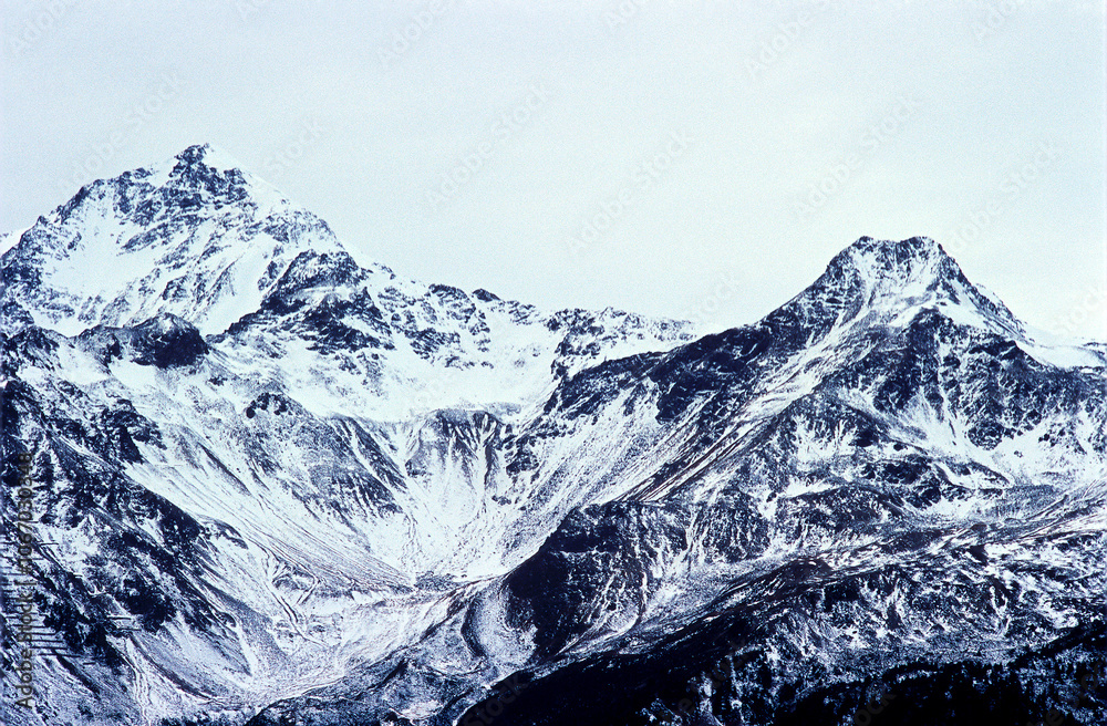 Obraz premium Mountain with light snowfall during a day with flat white light that creates a black and white effect