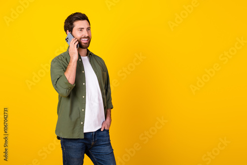 Portrait of nice young man communicate telephone wear khaki shirt isolated on yellow color background