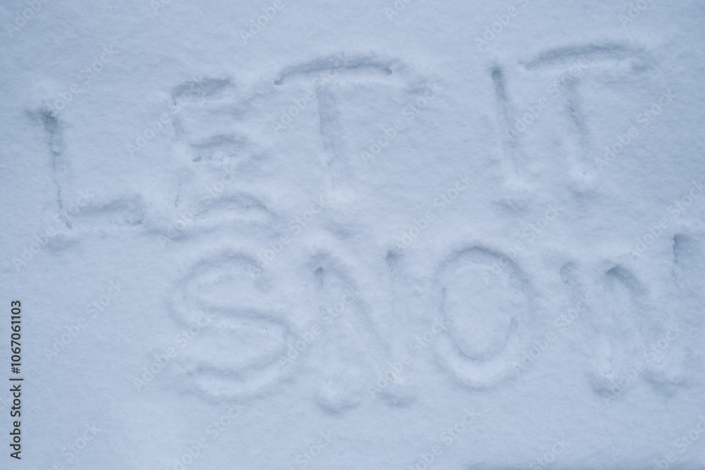 LET IT SNOW text handwritten in snowy winter season surface. Freezing cold weather. Climate change challenging conditions concept LET IT SNOW text handwritten in snowy winter season surface. Freezing cold weather. Climate change challenging conditions concept