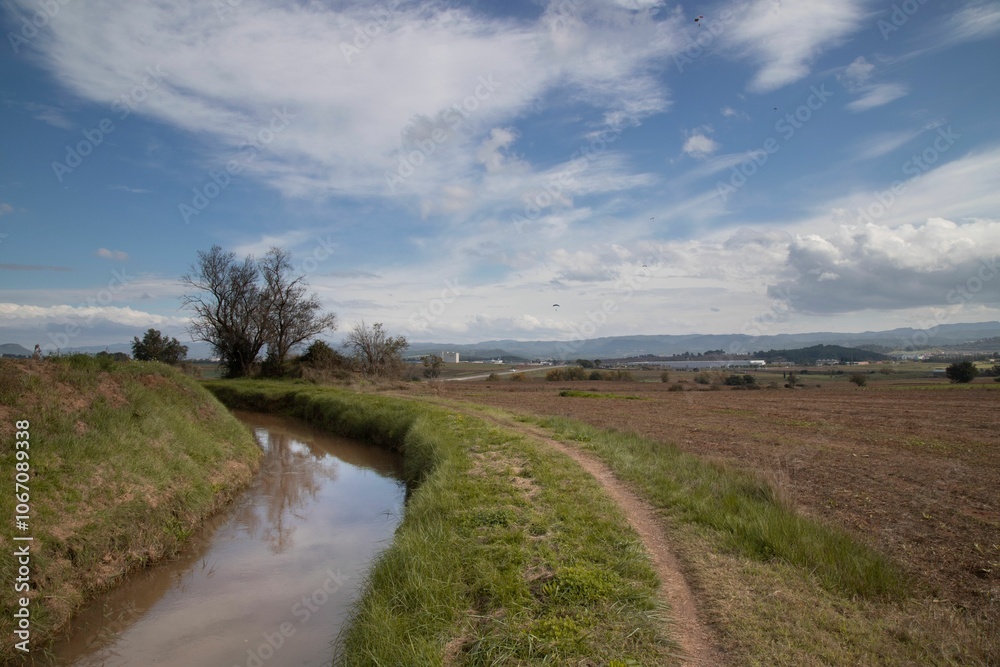 Scenic rural landscape with a stream and dirt path. Scenic rural landscape with a stream and dirt path.